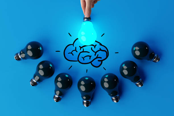 istock A hand holds a lit light bulb against the background of other extinguished light bulbs and a sketch of the brain. 1443237443