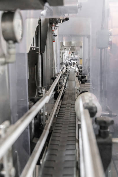 istock Industrial bottling machine at modern wine factory. Automatic conveyor line for wine-producing 1443239117