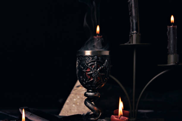 istock Witchcraft composition with candles, magic book and pentagram symbol. Altar for satanic rituals. Black magic and occult objects. 1443239560