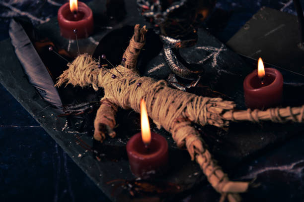 istock Voodoo doll in ritual scene close up, magic table with candles, witchcraft and spirituality concept. 1443239574