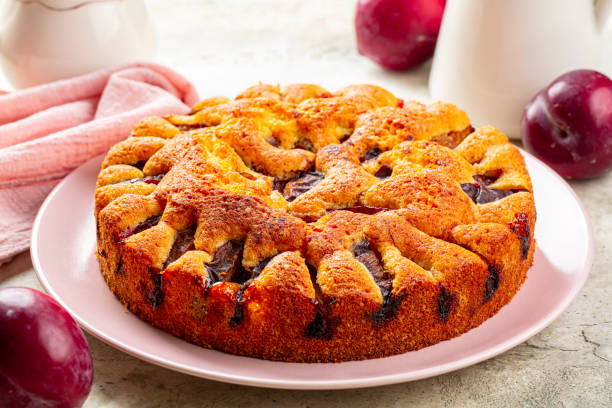Rustic Plum Torte or Cake and fresh red plums. Close-up.