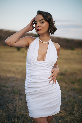 Gorgeous young woman posing in short white dress.