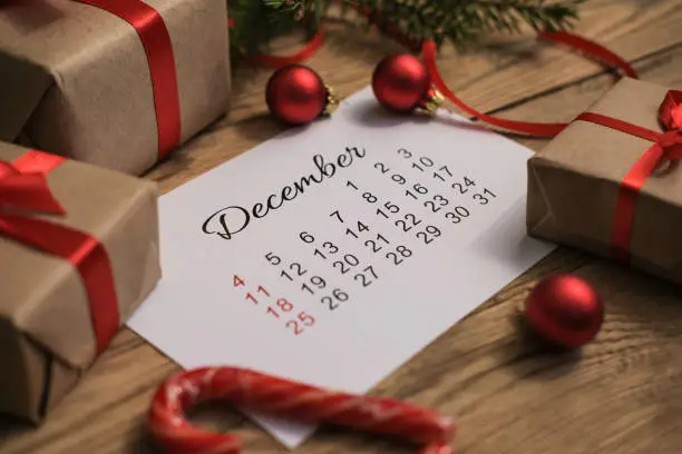 Photo of Gift boxes and December calendar on wooden table. Boxing day concept