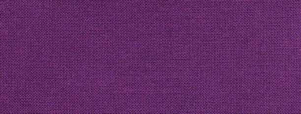 Photo of Texture of dark violet color background from textile material with wicker pattern. Vintage lavender fabric