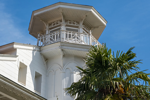 Low angle view of three houses with balconies under the blue sky at Destin, Florida. Row of houses with palm trees in between outdoors.