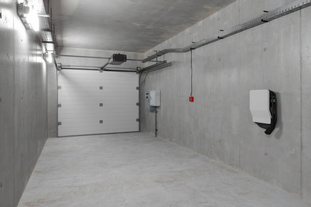 istock Modern Empty Garage With Electric Vehicle Charger Installed On The Wall 1443245293