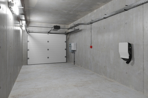 Modern Empty Garage With Electric Vehicle Charger Installed On The Wall