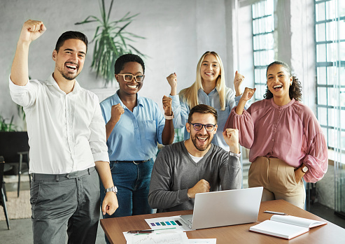 Group portrait of young business team celebrating success  in the office