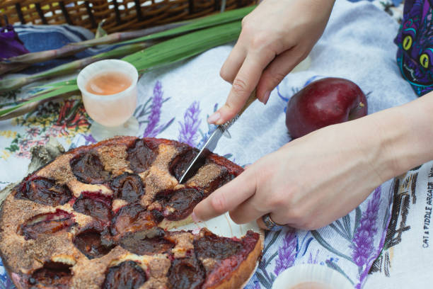 Close up prune pie concept photo. Delicious treats. Fresh fruits. Side view photography with female hands on background. High quality picture for wallpaper, travel blog, magazine, article