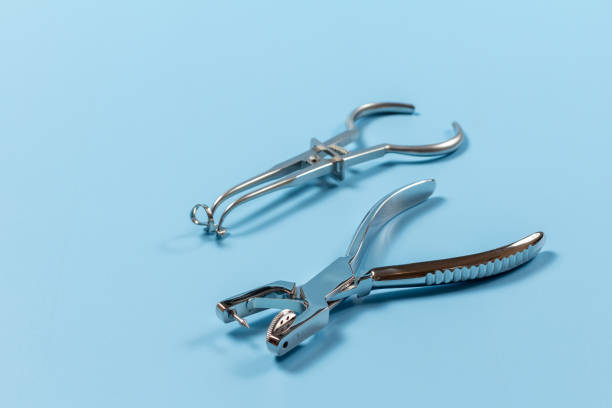 istock Rubber dam forcep and the dental hole punch on blue 1443247167