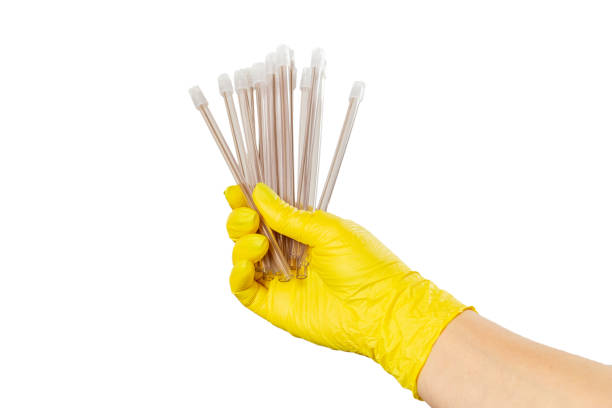 Dentist's hand in a latex glove with the saliva ejectors on the white isolated background. Medical tools concept.