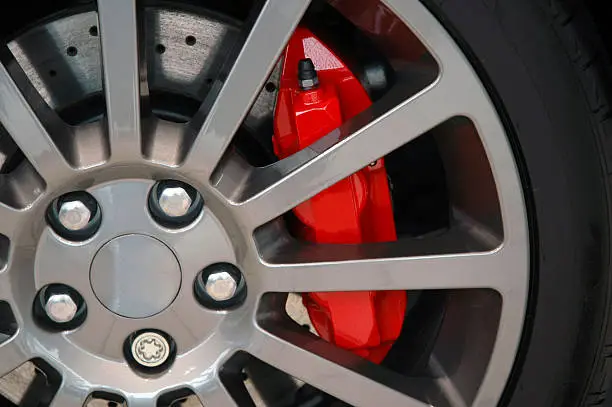 Alloy wheel with a red brake caliper from a sports car.