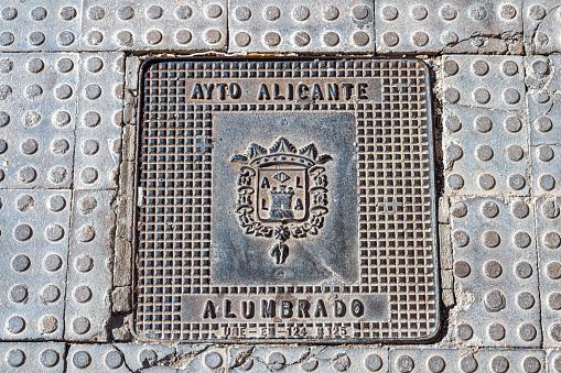 Alicante, Spain - July 12, 2022: Close-up of a metal plate on a wall. The plate bears the Alicante Ayuntamiento logo and the inscription, \