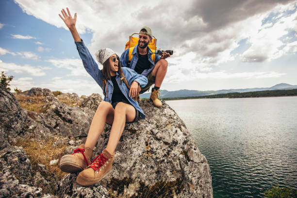 istock Hikers with backpacks sitting on cliff enjoying at the mountain lake 1443252438