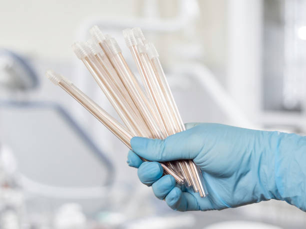 istock Dentist's hand in glove with saliva ejectors. 1443254294