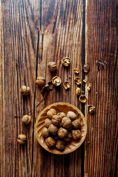 istock Walnuts in a wooden bowl on a rustic wooden table. 1443256636