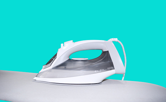 electric iron on ironing board Housework and housekeeping