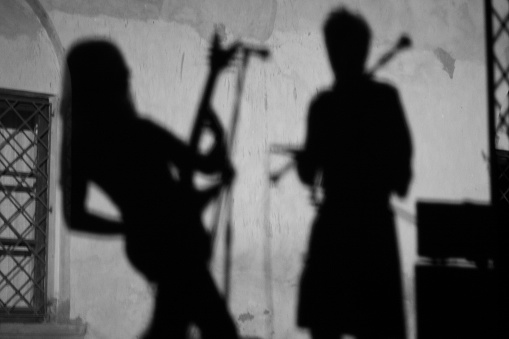 Two men, young music bend on rehearsal on stage in music studio.