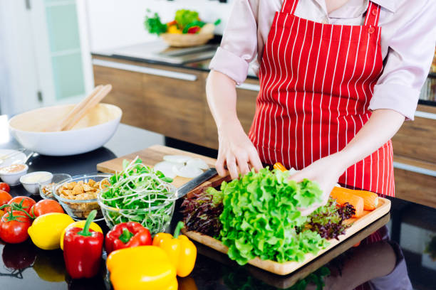 Woman making salad dressing, shooting only hands on island modern kitchen