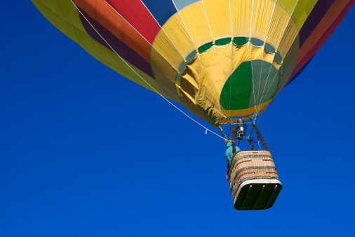 A hot air balloon lands on a meadow near Goreme in Cappadocia