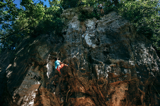 Rock climbers assisting and practicing climbing in nature