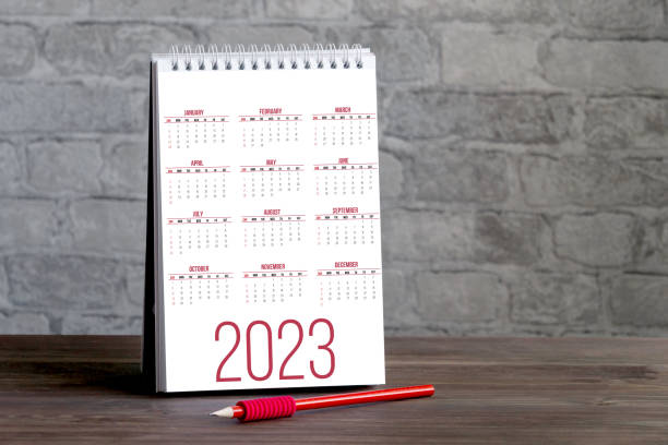 istock Notebook with desktop calendar for 2023. Table for planning and reminders on desktop in close-up against brick wall. Concept of welcome to two thousand twenty-third year. 1443270892