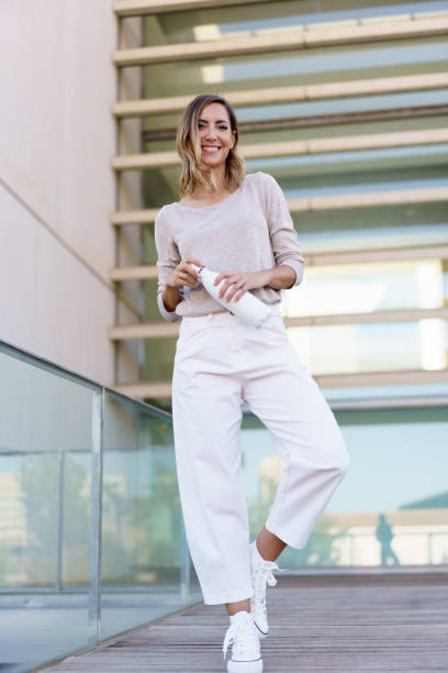istock Cheerful female with bottle on footbridge 1443270947