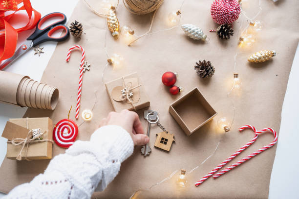 istock Key to house with keychain on cozy home in gift box with Christmas decor packaging. Pack present for New Year, Christmas. Building, project, moving to new house, mortgage, rent, purchase real estate 1443271491