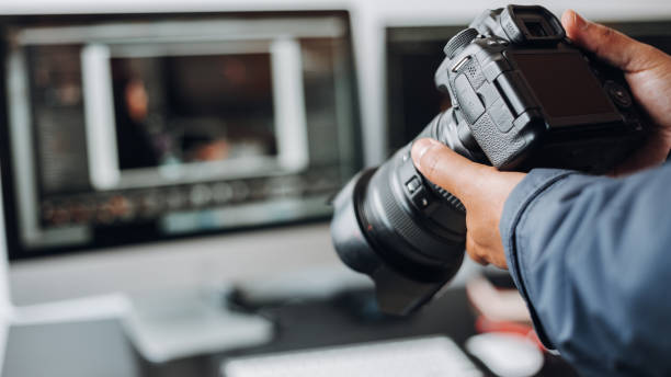 fotograf ruční fotoaparát a počítač na stole - fotograf - stock snímky, obrázky a fotky