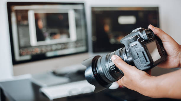 istock photographer hand camera and computer on desk 1443275724