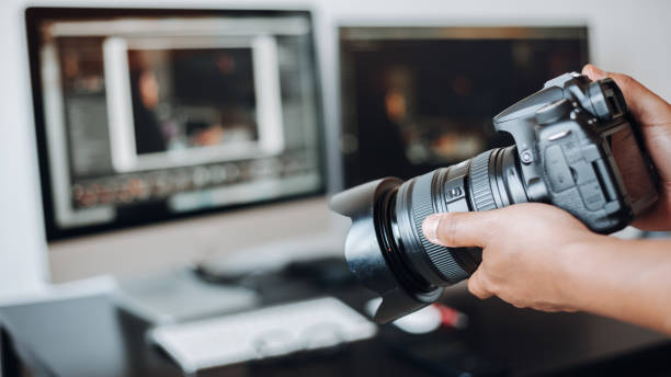 istock photographer hand camera and computer on desk 1443275737