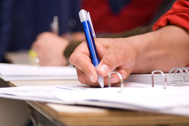 istock Close-up of a hand that is writing on paper with a blue pen 144327621