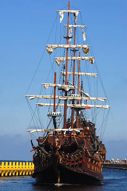 Old sailing-ship on the blue sky background