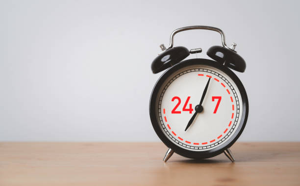 istock Nonstop Worldwide service available support concept , Number 24 hours and 7 days full-time contact to black alarm clock on wooden table. 1443282247