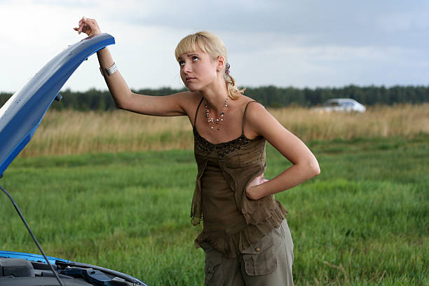 istock young blond woman with her broken car 144328298