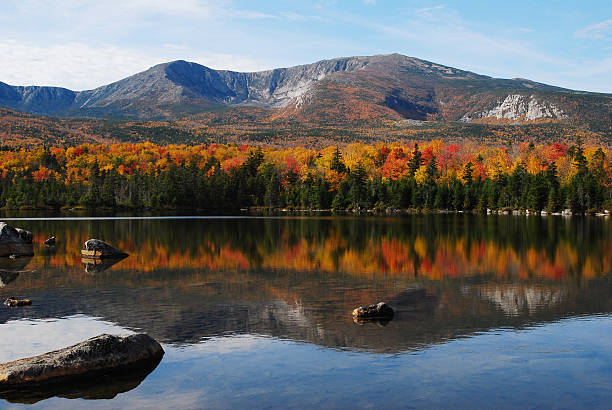 A mountain looking over a lake in autumn in Maine Vivid, saturated, fall colors at Sandy Stream Pond with the North Basin (next to Mount Katahdin) as a back-drop. Baxter State Park, Maine. morph transition stock pictures, royalty-free photos & images