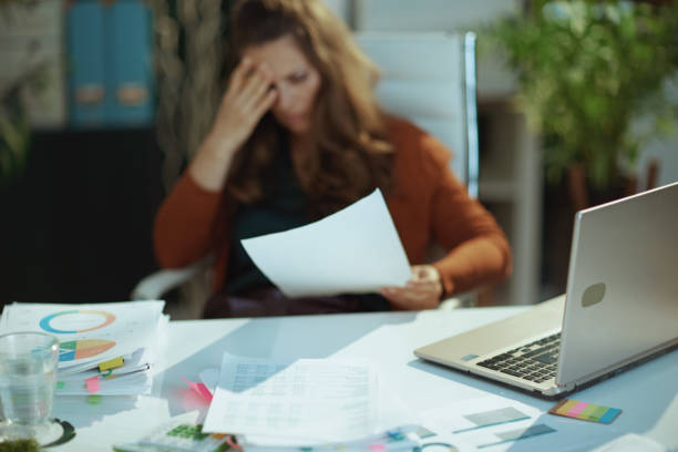istock Table with documents in green office and woman with document 1443284758