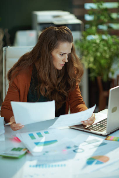 istock business owner woman in green office working with documents 1443284760