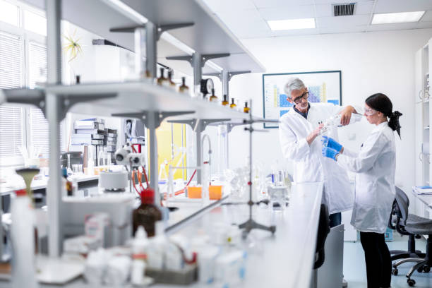 Two colleagues seen in a research lab working with some medical bottles stock photo