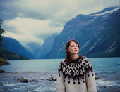 Woman in sweater walking near the lake in Norway