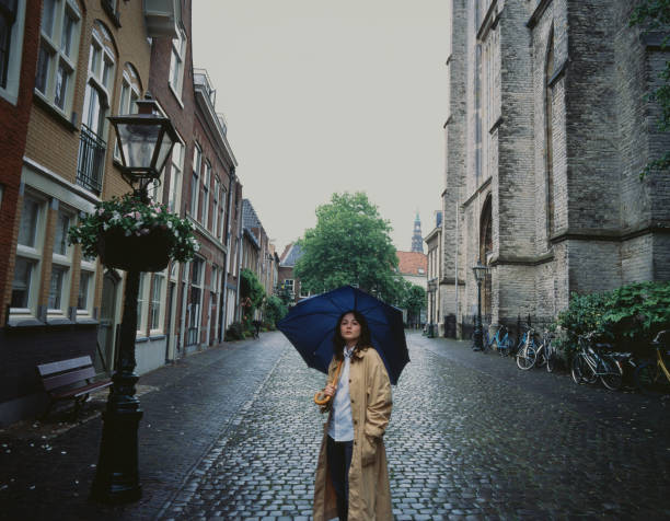 Young Caucasian woman walking in Leiden under the rain
