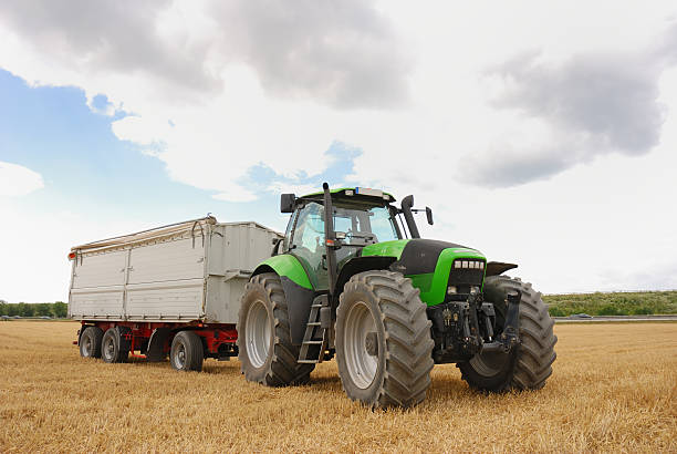 istock tractor and trailer on harvested crop field 144328976