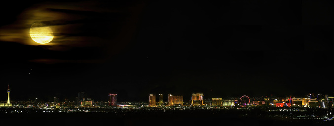 The entire Las Vegas strip at night from afar under a full moon