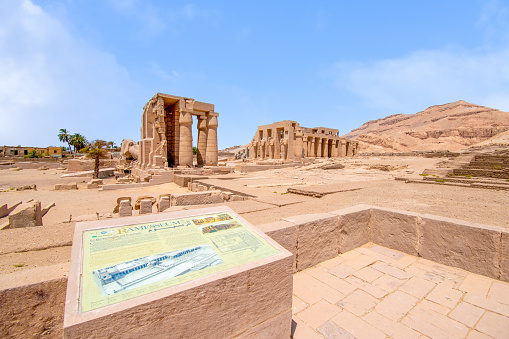 Ancient columns in a row with carved egyptian hieroglyphics