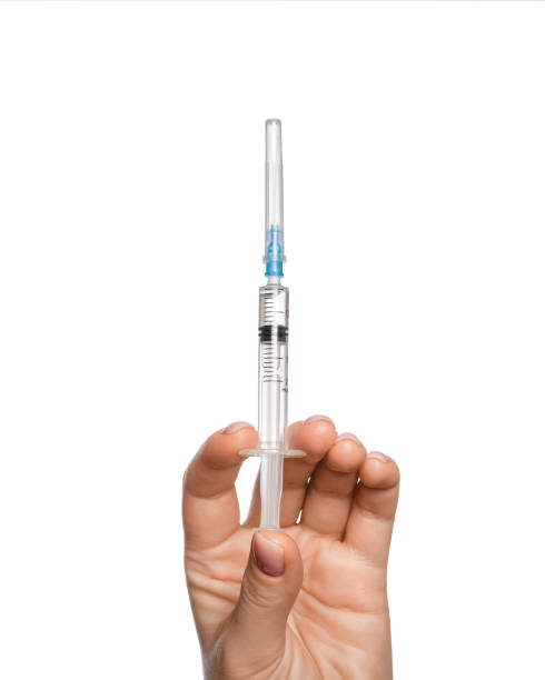 istock Medical syringe in hand with liquid for injection on white background 1443294935