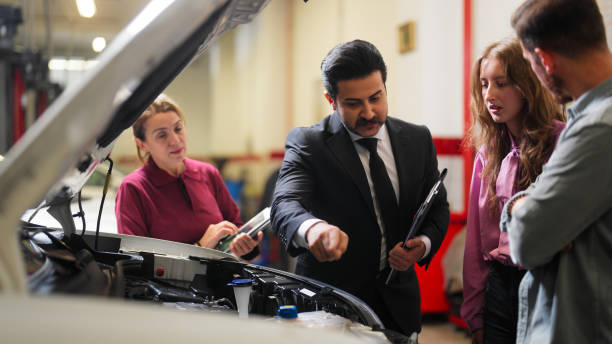 istock Car insurance expert checking broken car and discussing with couple 1443295903