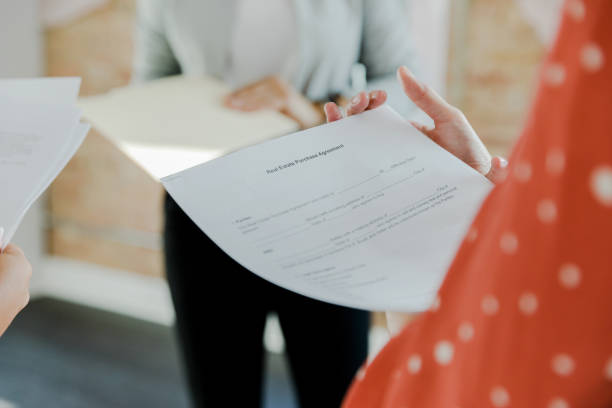 istock Focus on purchase agreement contract held by unrecognizable businesswoman 1443298758