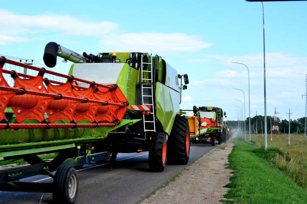 istock row of combine harvesters going forward on the road with blue sky on background 1443301678