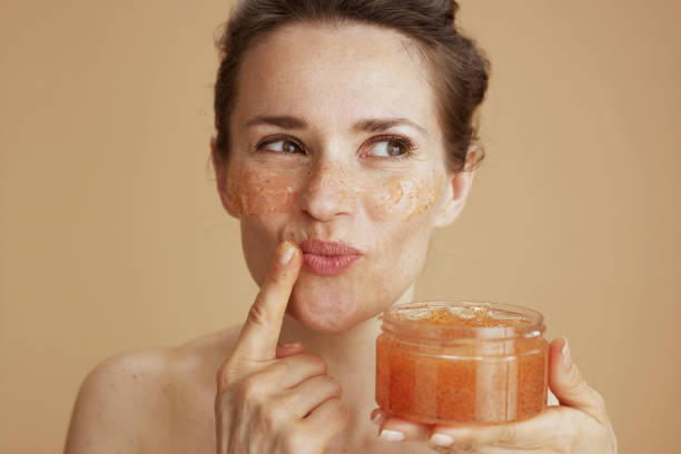 mujer moderna feliz con exfoliante facial - exfoliacion fotografías e imágenes de stock