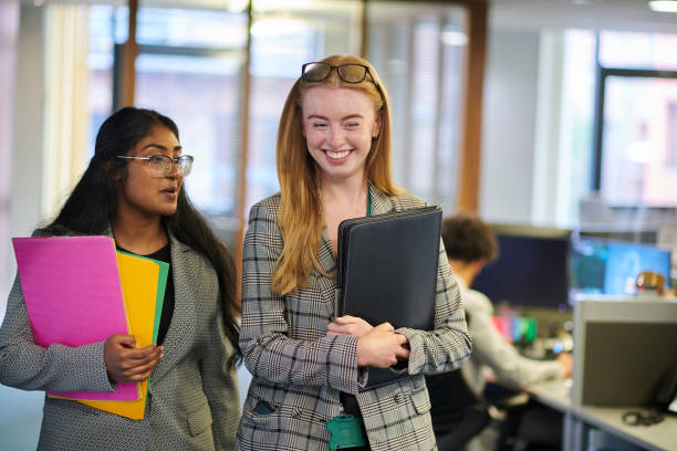 happy young paralegals walking through the office happy young paralegals walking through the office trainee stock pictures, royalty-free photos & images